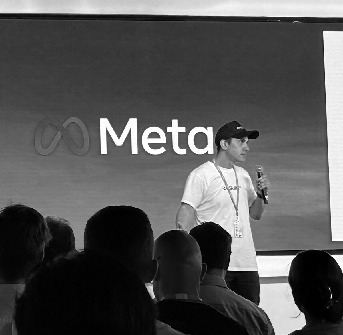 Kerran on stage with a microphone in front of a Meta logo